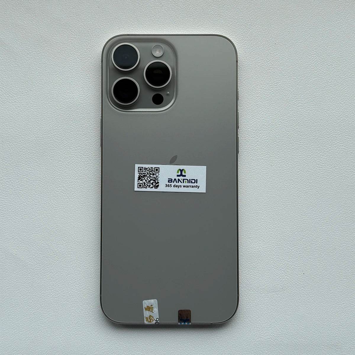 Apple iPhone 16 Pro Max 256GB unlocked in silver showing the back with triple camera lenses and warranty sticker