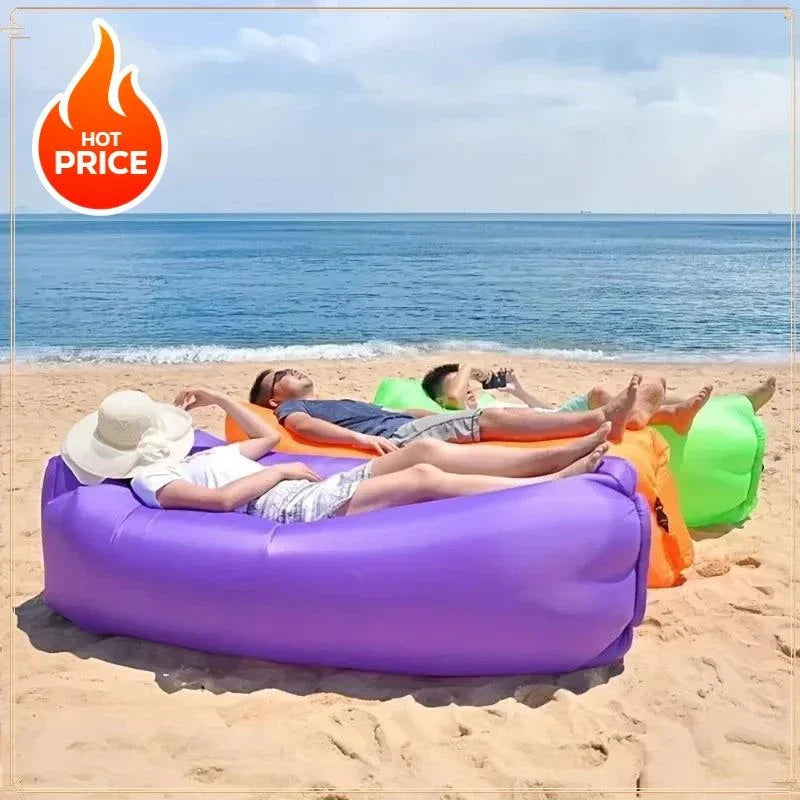 Three people relaxing on colorful inflatable lazy sofa bed on the beach with ocean background
