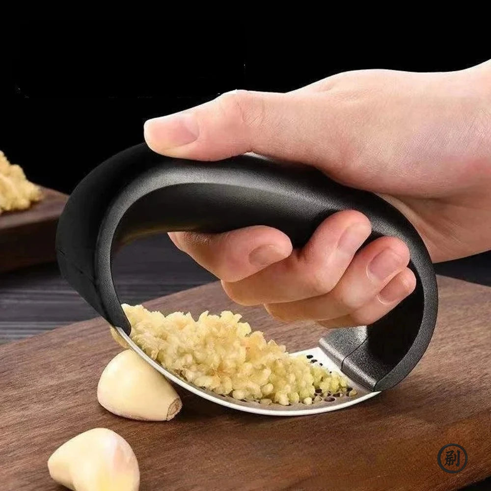 Merit Sell stainless steel garlic press with ergonomic black handle crushing garlic cloves on wooden board