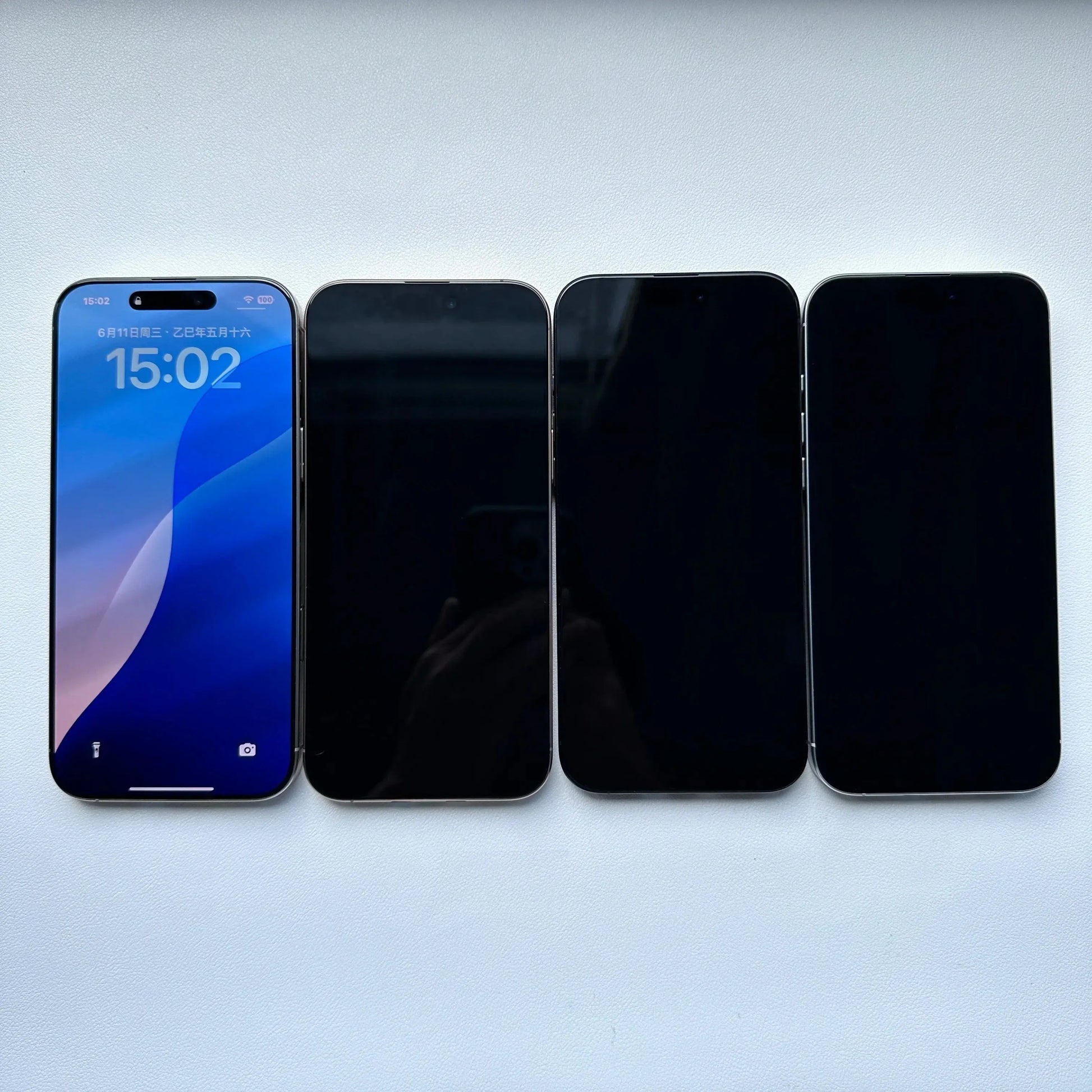 Four smartphones including one unlocked iPhone 16 Pro Max for sale with screen on and three with screens off